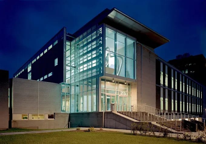 Façade vitrée d’un palais de justice moderne au crépuscule, éclairée de l’intérieur
